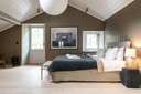 Bedroom with wood-panelled walls and soft lighting at Brücke 49.