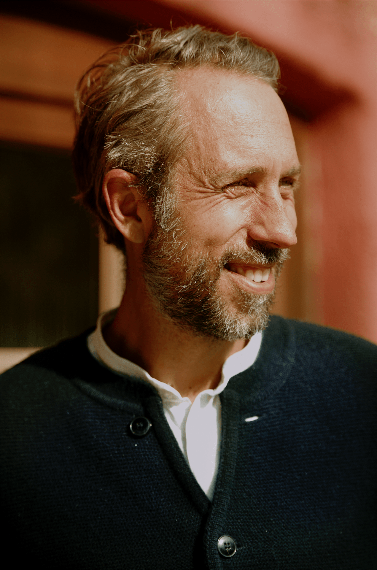 Portrait of Christian Mueller smiling indoors in warm natural light at Rosso House & Farm.