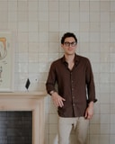 George DiStefano, Owner and Creative Director of The James Bradley, standing in front of a tiled fireplace wall.
