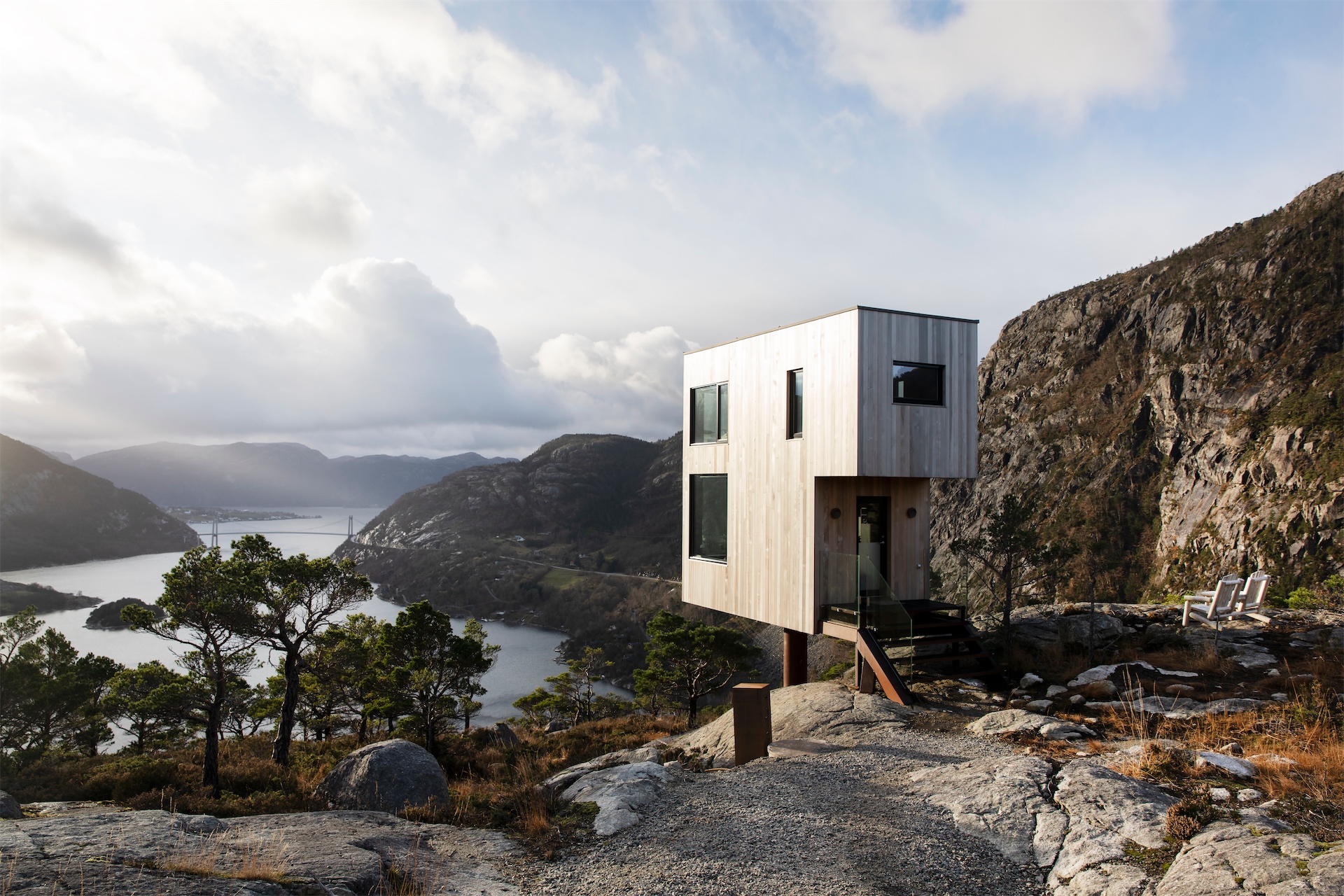 Vipp Bolder cabin overlooking fjord and mountain landscape.