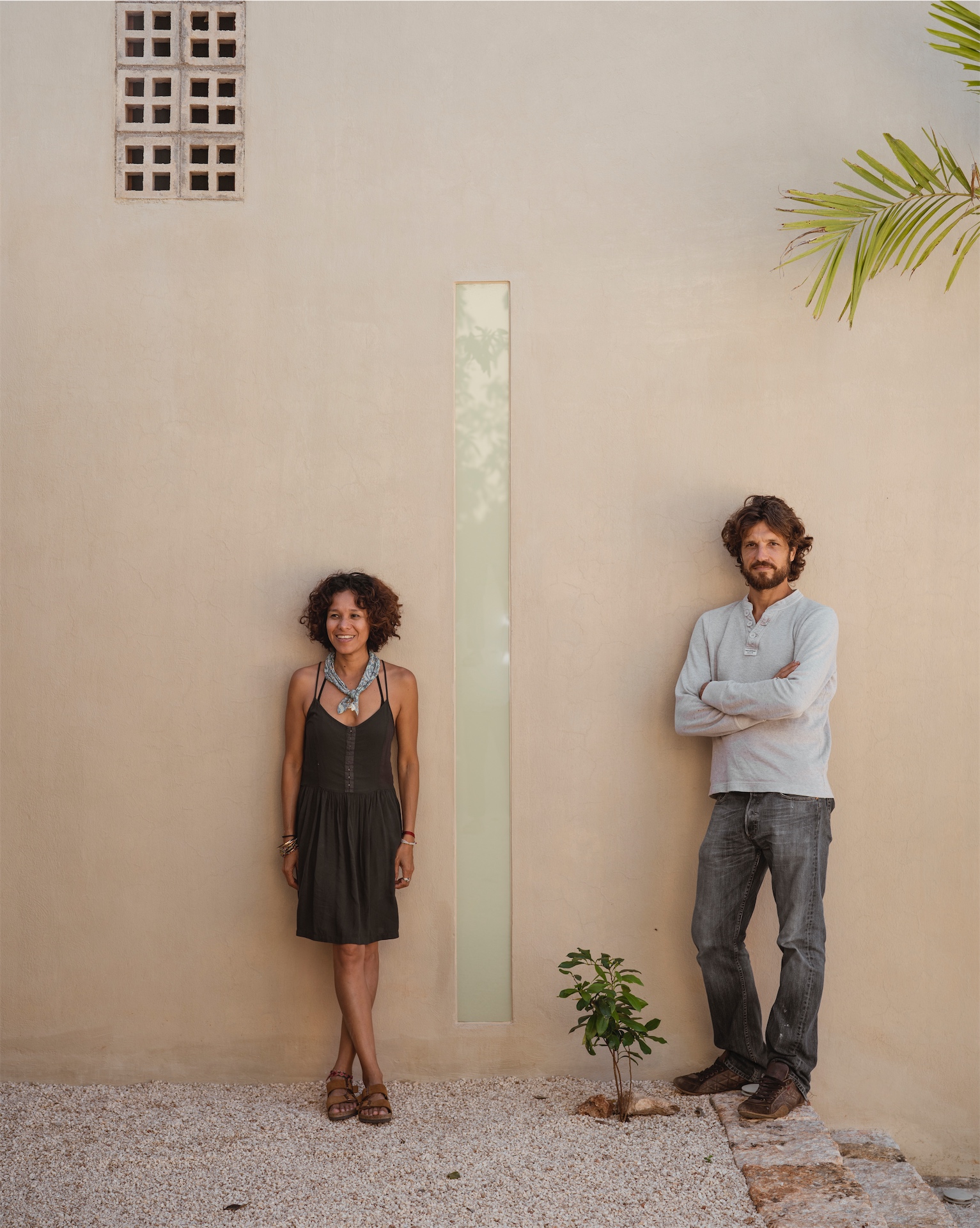 Co-owners of Galopina standing against a minimalist courtyard wall.